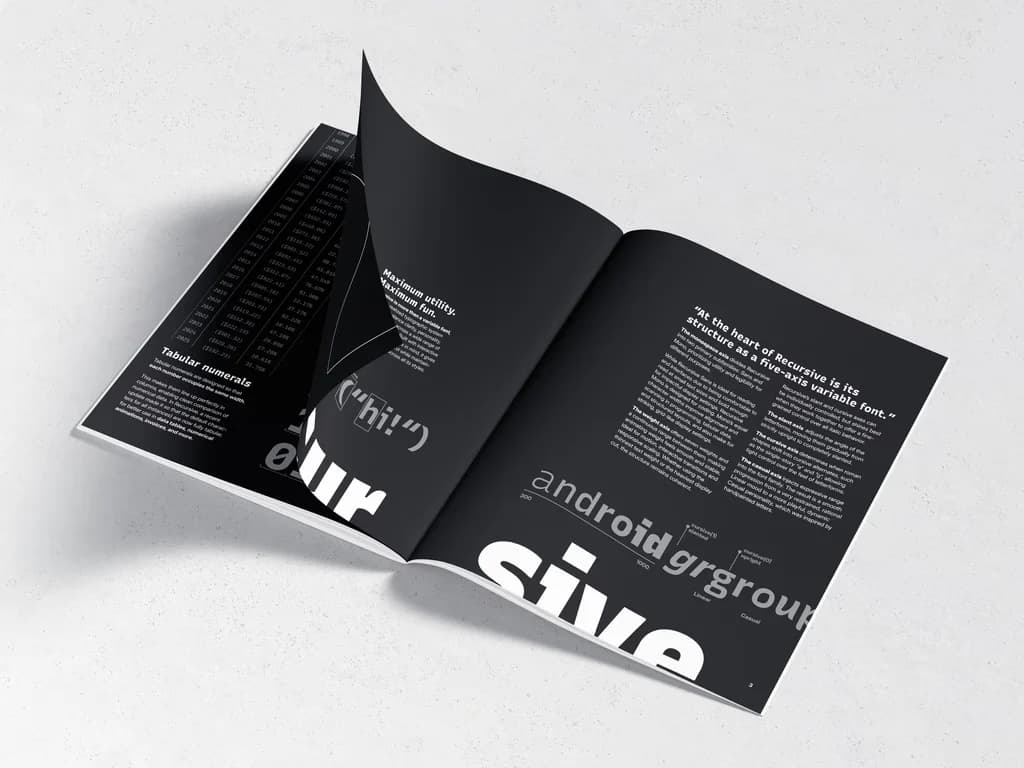 A booklet lying open on a pale surface, photographed at an angle. Both pages are black, set with white type at several sizes: a pull quote about a five-axis variable font, a column headed Tabular numerals, and oversized letterforms running off the edges of the spread.